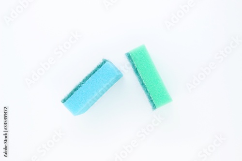Multi-colored dishwashing sponges are placed on a white background