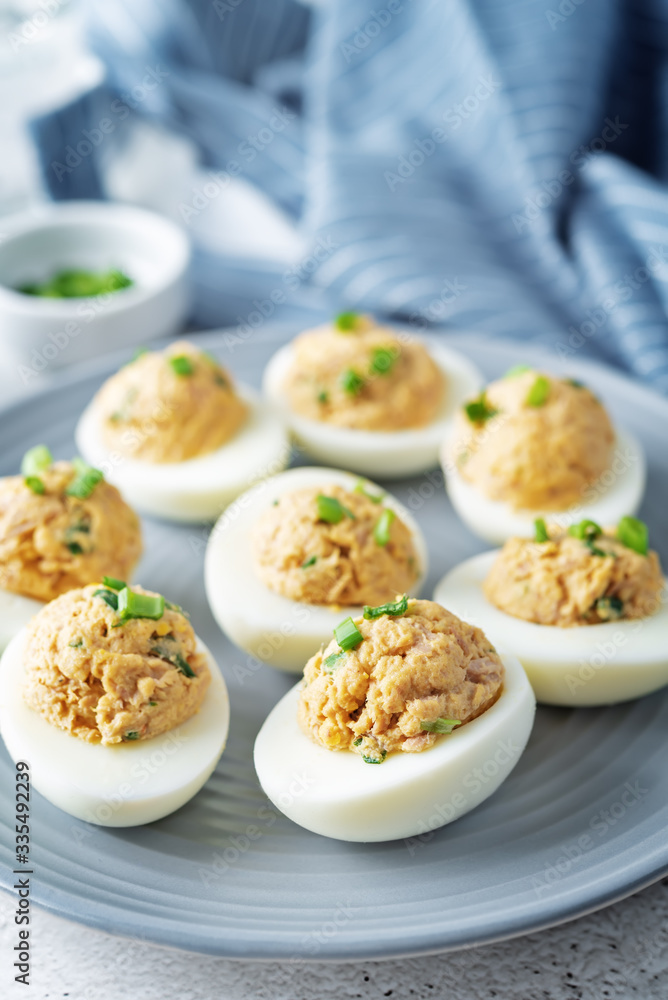 Canned Tuna deviled eggs with scallion on a light background