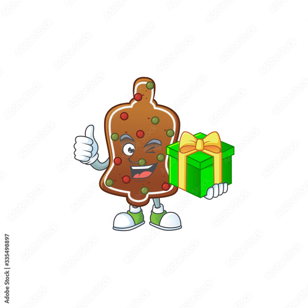 Smiley gingerbread bell cartoon character holding a gift box Smiley gingerbread bell cartoon character holding a gift box