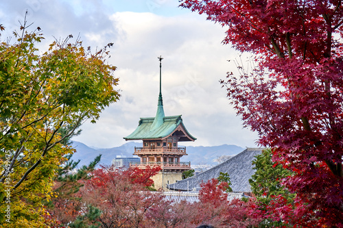 Starnge shape temple through the gap of colorful tree leaves photo