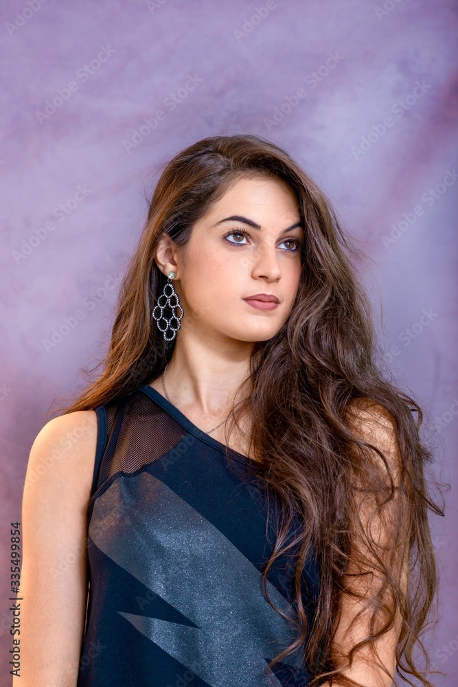 black hair woman portrait with brown eyes on a gray background , Caucasian ethnic group is looking into the camera with a serious expression on her face. White girl with long black hair and brown eye black hair woman portrait with brown eyes on a gray background , Caucasian ethnic group is looking into the camera with a serious expression on her face. White girl with long black hair and brown eye