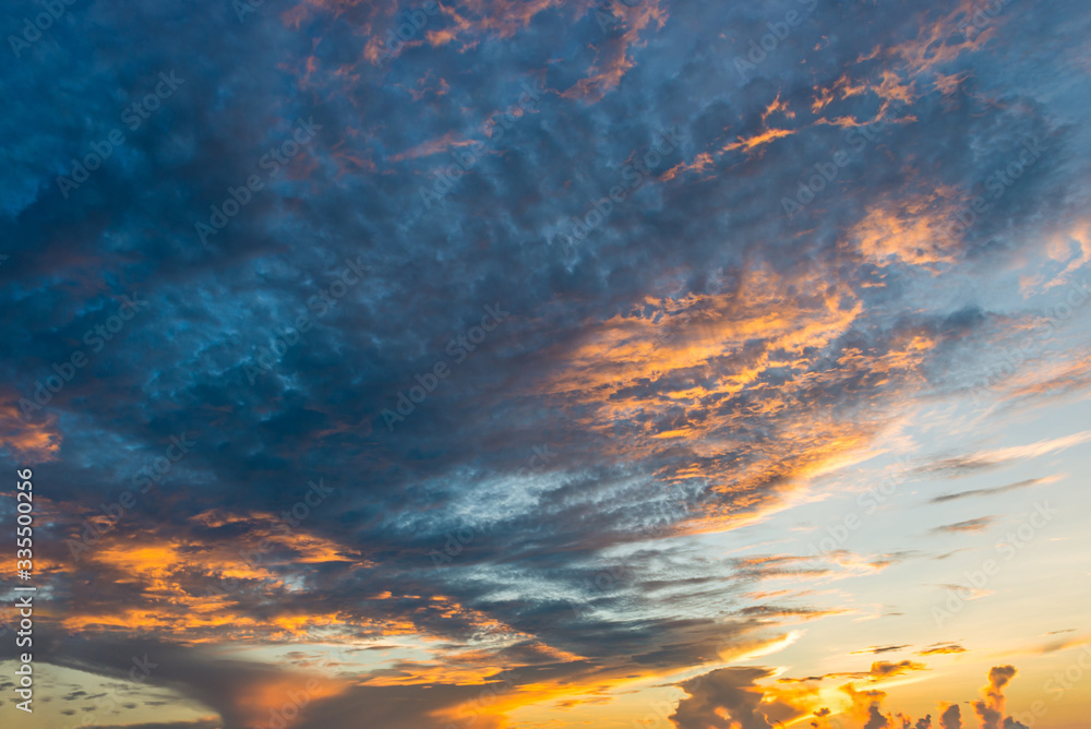 Obraz premium Dramatic twilight sky with orange clouds at sunset