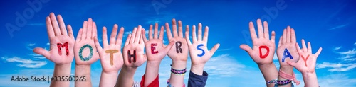 Children Hands Building Colorful English Word Mothers Day. Blue Sky As Background