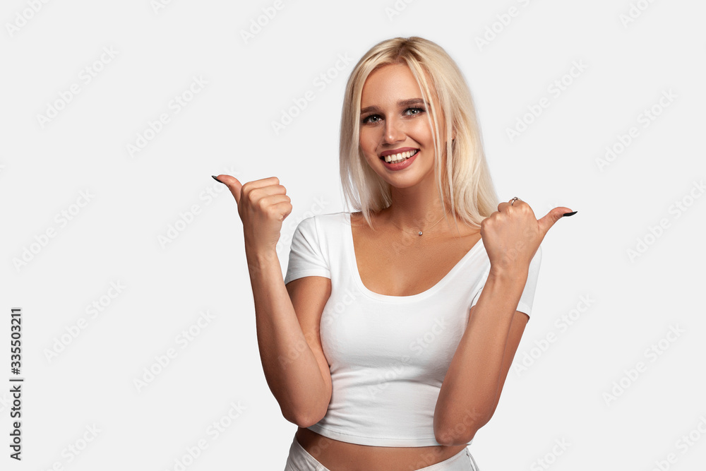 Young blonde woman over isolated white background with thumbs up gesture and smiling. Portrait of girl in white t-shirt. Mockup. Young blonde woman over isolated white background with thumbs up gesture and smiling. Portrait of girl in white t-shirt. Mockup.