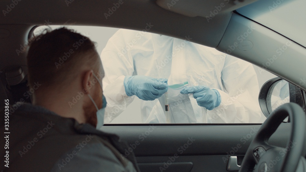 Patient is being tested in his vehicle on a drive-through coronavirus COVID-19 testing location. Pandemic, infection