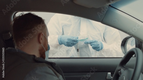 Patient is being tested in his vehicle on a drive-through coronavirus COVID-19 testing location. Pandemic, infection © supamotion