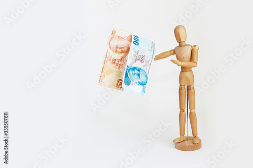 wooden yellow mannequin holding currency money turkish lira