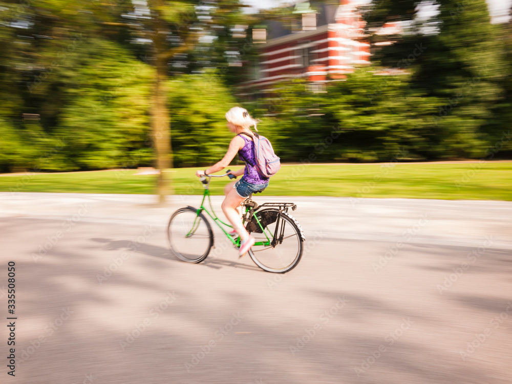 woman cycling in the park during a summer day woman cycling in the park during a summer day