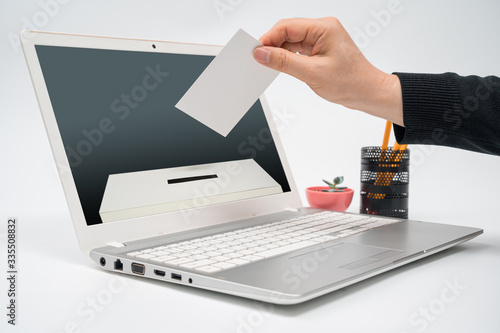 Konstfotografi Online voting concept with a man with a ballot in hand putting a ballot toward the computer monitor