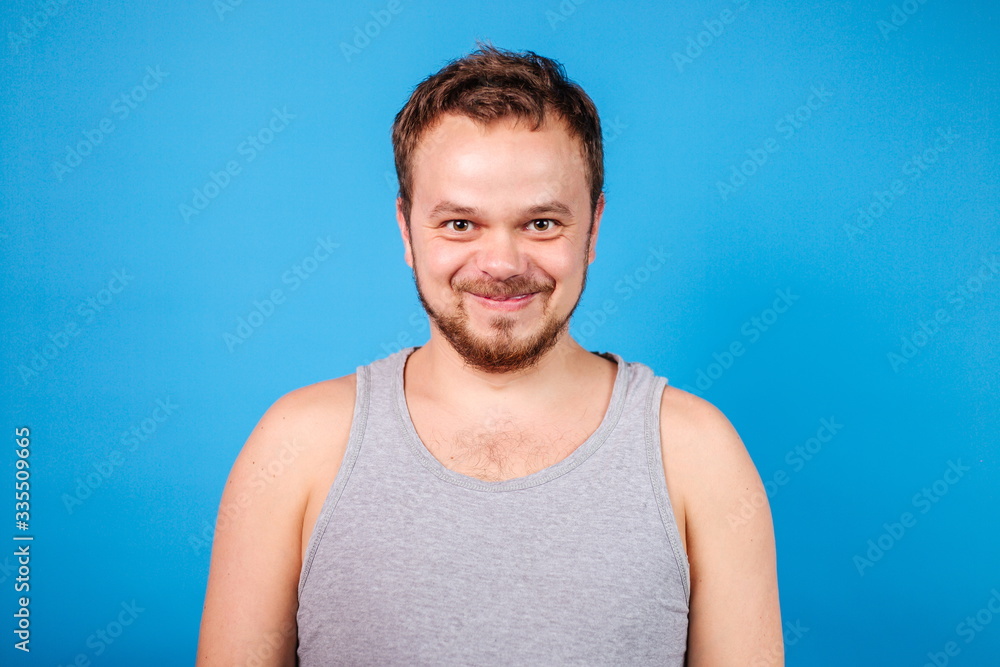 Fototapeta premium Quarantined domestic man standing on a blue background in a t-shirt