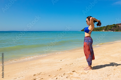 Asian Thai woman practicing yoga in Haad Yao West beach, Koh Phangan island, Thailand