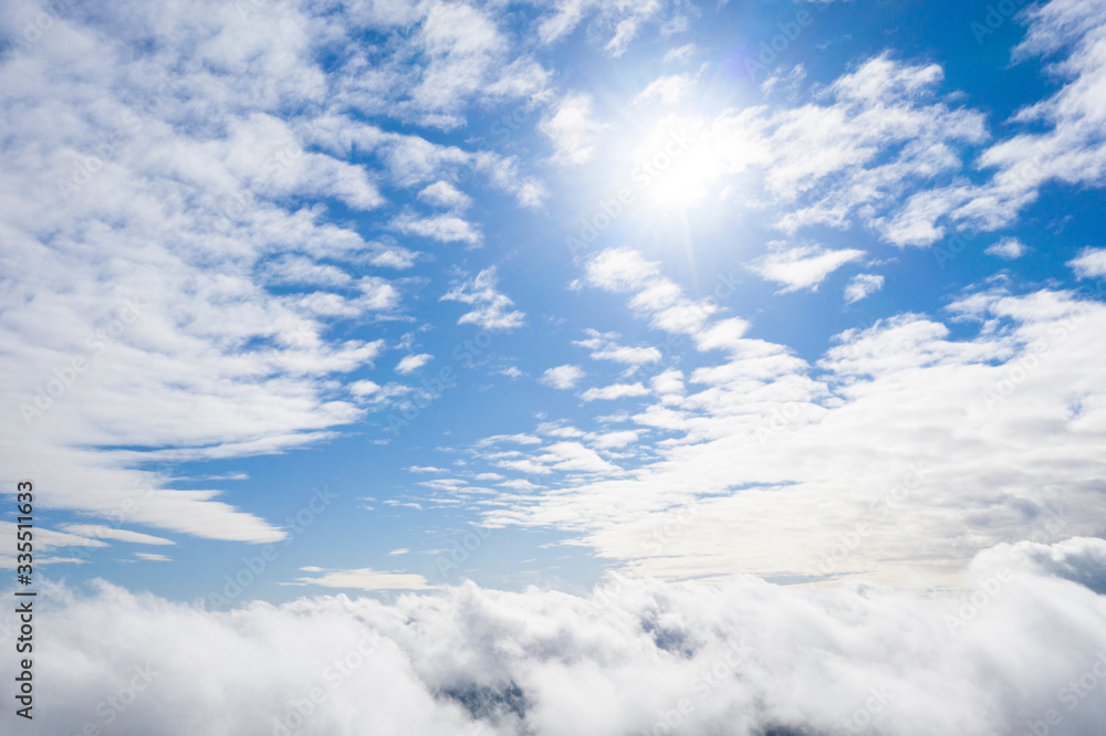 Aerial view white clouds in blue sky. View from drone. Aerial top view cloudscape. Texture of clouds. View from above. Sunrise or sunset over clouds. Panorama clouds