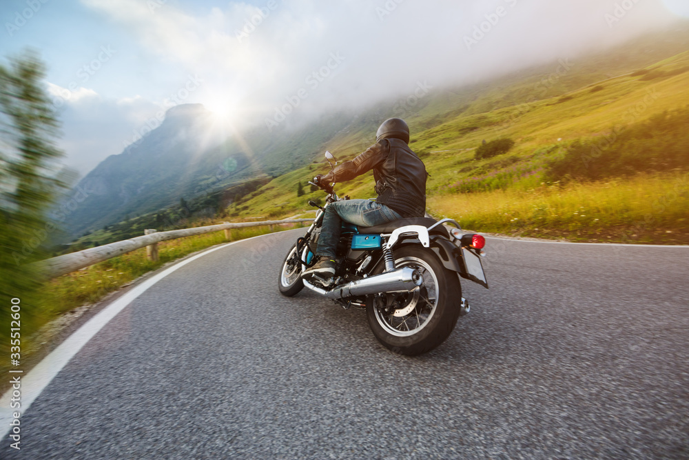 Motorcycle driver riding in Dolomite pass, Italy, south Europe.
