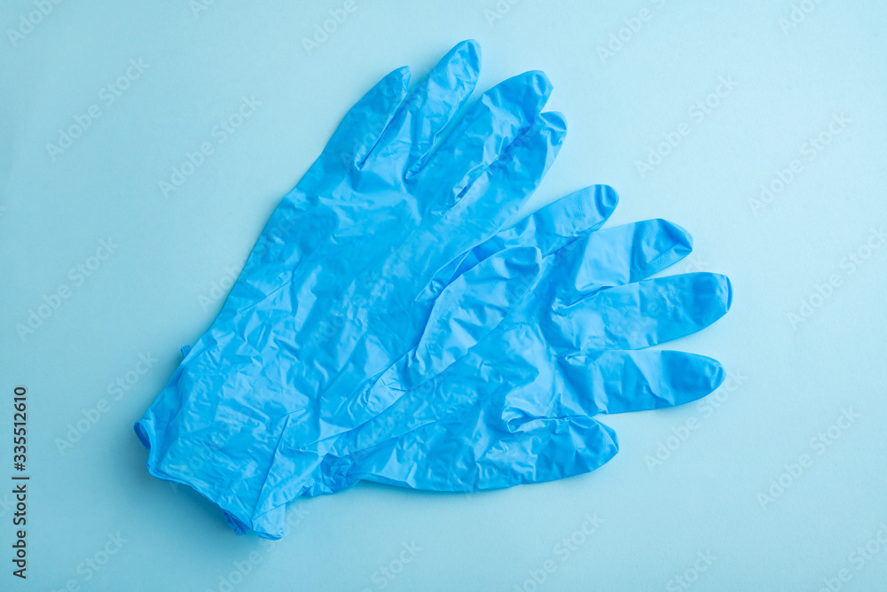 Fototapeta premium Disposable gloves on light blue background