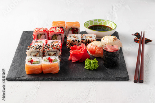 Japanese cuisine. Assorted sushi maki gunkan roll on white table