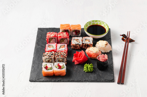 Japanese cuisine. Assorted sushi maki gunkan roll on white table