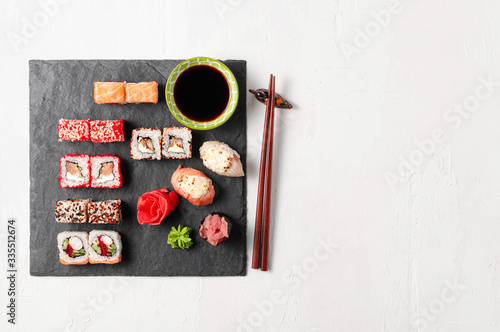 Japanese cuisine. Assorted sushi maki gunkan roll on white table