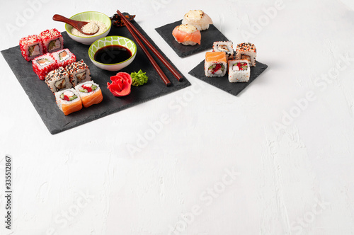 Japanese cuisine. Assorted sushi maki gunkan roll on white table