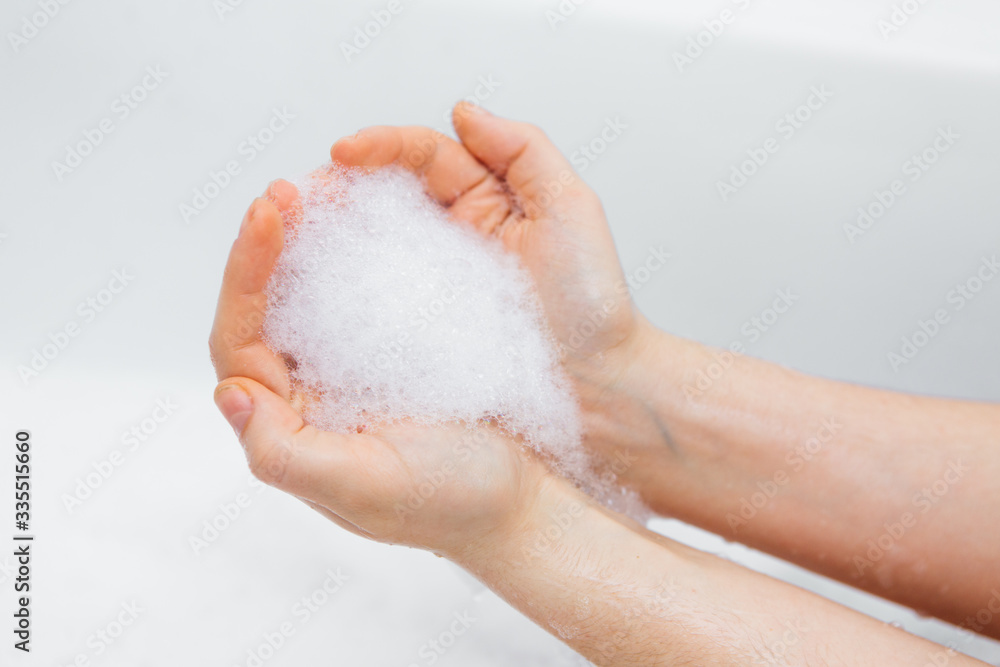 Fototapeta premium Foam in the hands of a girl, washing hands
