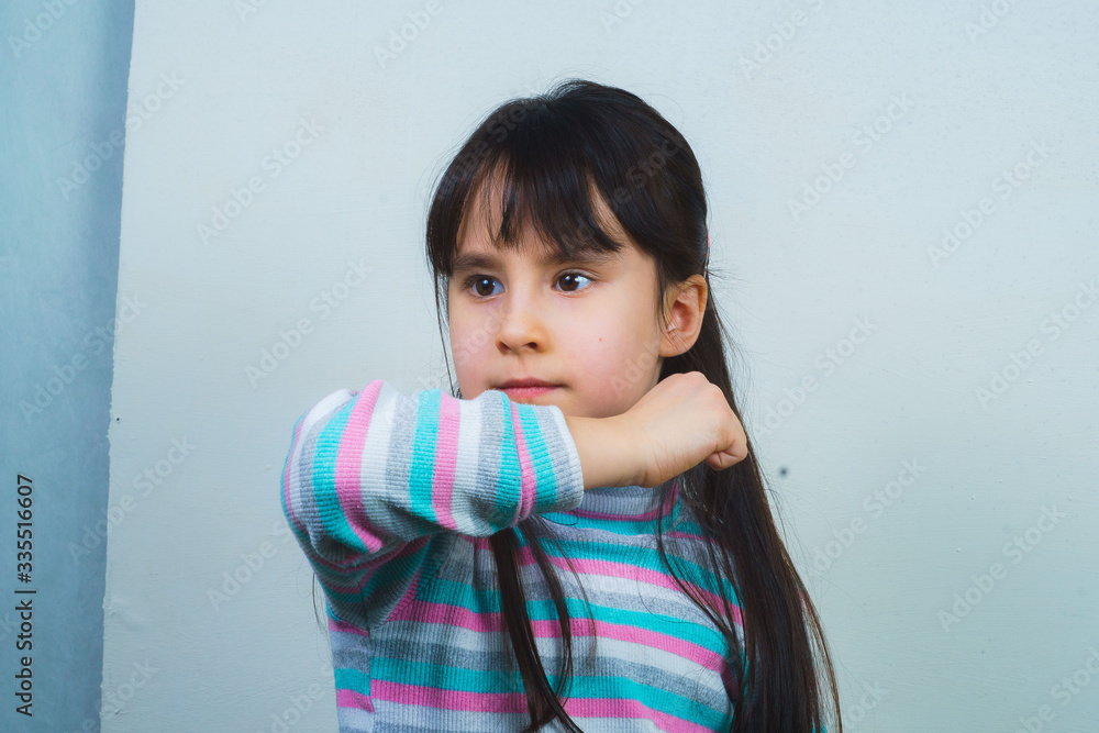 Portrait of a cheerful child with long hair and a striped sweater. girl fooling around Portrait of a cheerful child with long hair and a striped sweater. girl fooling around