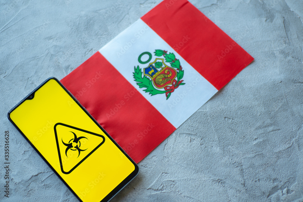 Epidemiological situation in the country Peru. Flag and smartphone with news and a biohazard symbol.