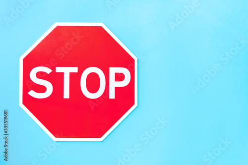 Red prohibition road sign stop on left part of blue background. Prevention warning symbol shows traffic ban. Attention icon indicates car no movement. Caution, alert, danger, risk concept.
