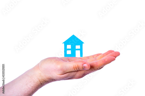 Person holds blue house isolated on white background