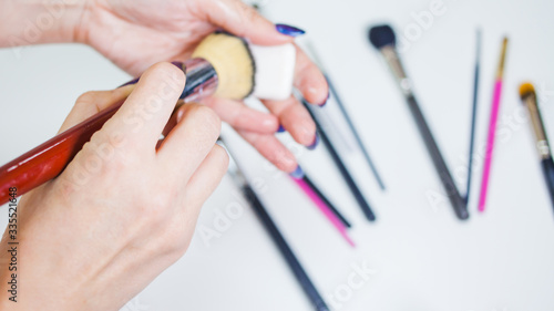 Hygienic care of makeup artist tools  women s hands wash the brush from cosmetics  soap and cleaning products 