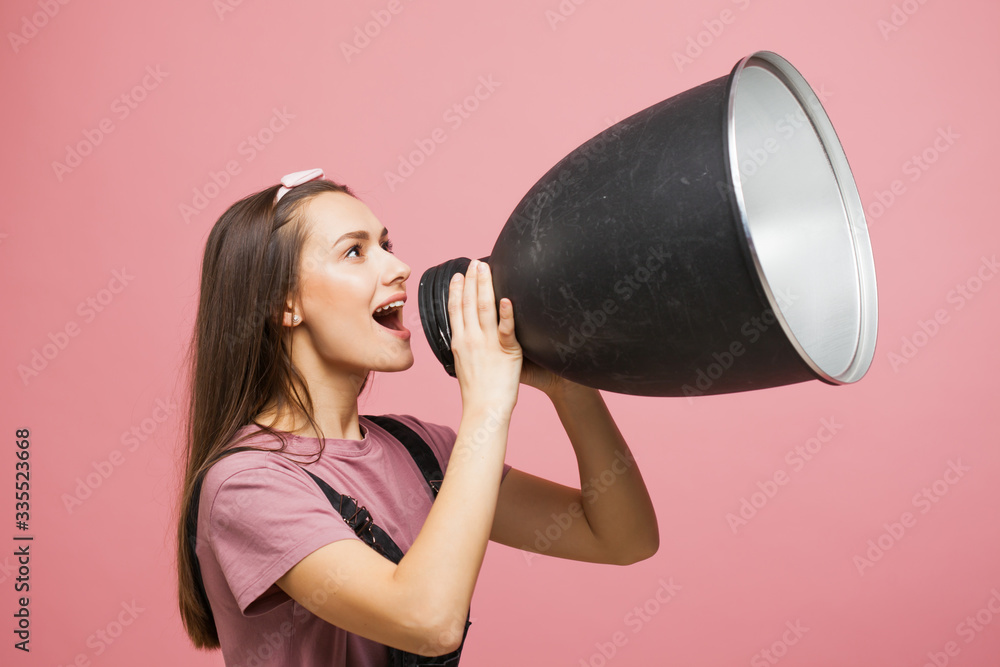 young activist shouts into a megaphone, a young girl in a jumpsuit young activist shouts into a megaphone, a young girl in a jumpsuit