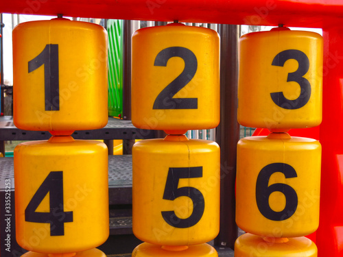 plastic educational numbers on the oytdoor Playground: yellow bobbins with black numbers photo