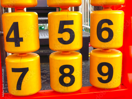 plastic educational numbers on the oytdoor Playground: yellow bobbins with black numbers photo