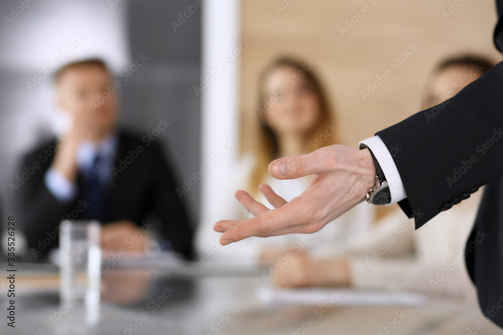 Business presentation. Businessman giving speech to colleagues and partners at corporate meeting or conference, close-up of speaker hands Business presentation. Businessman giving speech to colleagues and partners at corporate meeting or conference, close-up of speaker hands