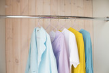 clothes of pastel shades on hangers. analysis of the wardrobe