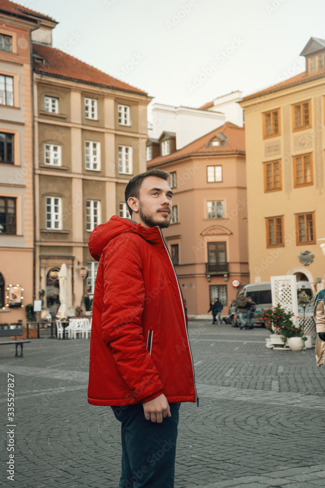 Young male tourist walking on one of the most touristic places in central Europe. Old town square in Warsaw, Poland Young male tourist walking on one of the most touristic places in central Europe. Old town square in Warsaw, Poland