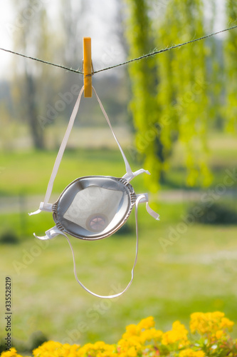 Medical face masks for protection against corona virus hung in the sun drying for reuse during the Covid-19 flu crisis.