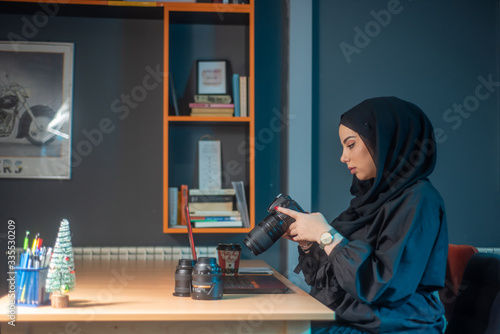 Beautiful two girls with hijab hanging out, typing on laptop, learining about photography and study photo