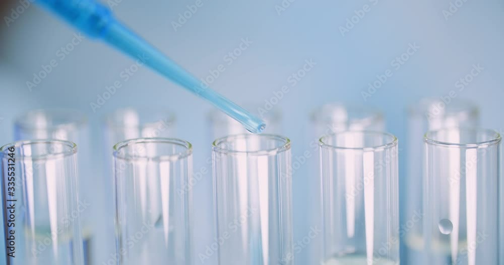 Extreme Close up of Pipette Dropping Water into Sample Tube at Laboratory Extreme Close up of Pipette Dropping Water into Sample Tube at Laboratory