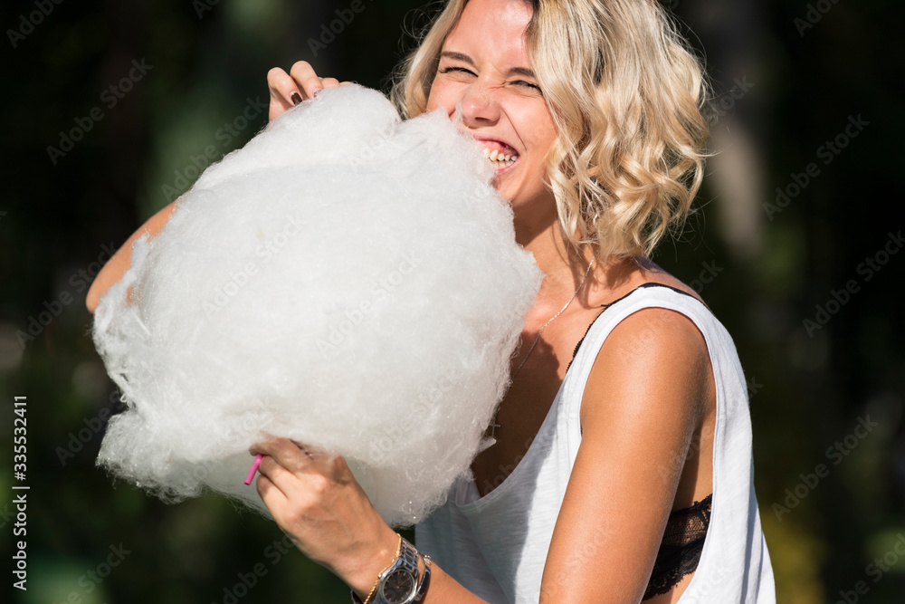 Girl eating sweet cotton candy in a summer park
Girl eating sweet cotton candy in a summer park