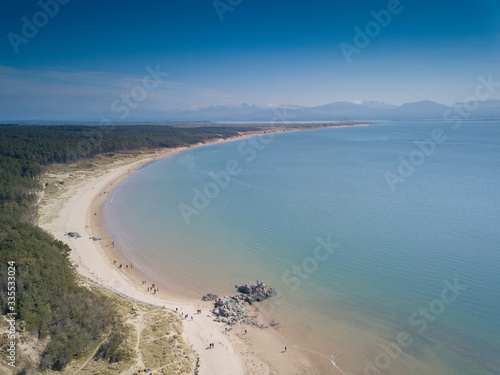 Aerial view of Llanddwyn Bay and Snowdonia Mountains, Newborough, Anglesey, Wales, UK