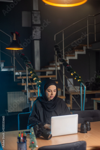 Beautiful two girls with hijab hanging out, typing on laptop, learining about photography and study photo