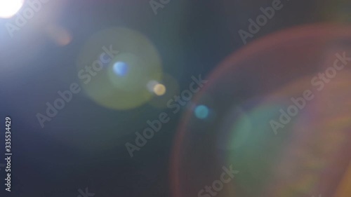 Beautiful abstract defocused lens flare on a dark background. Real light leaks and lens flare.