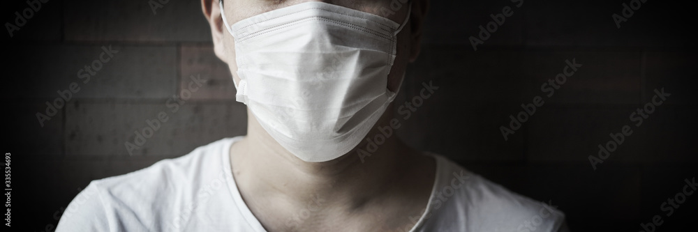 Man wearing protection face mask against coronavirus. Coronavirus, a man in a mask on a dark background. Title about the outbreak of the corona virus in China, illness. Epidemic.