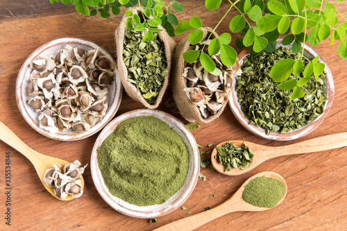 Moringa, leaves, seeds, powder on a wooden background - Moringa oleifera