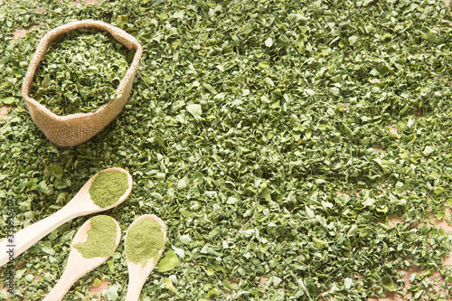 Moringa, leaves and powder on a wooden background- Moringa oleifera photo