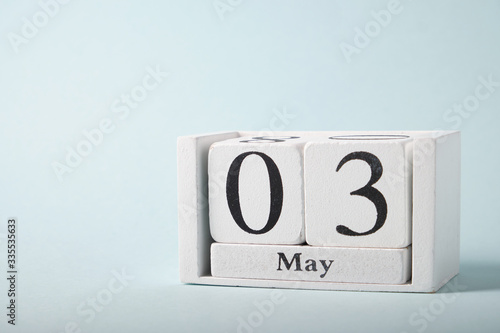 Wooden calendar on a blue background with the date of May 3 © grek881