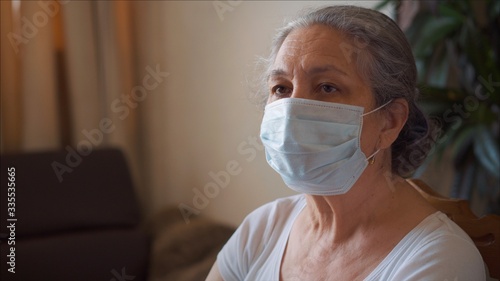 Pandemic. Senior Woman do office job at home wearing protective mask