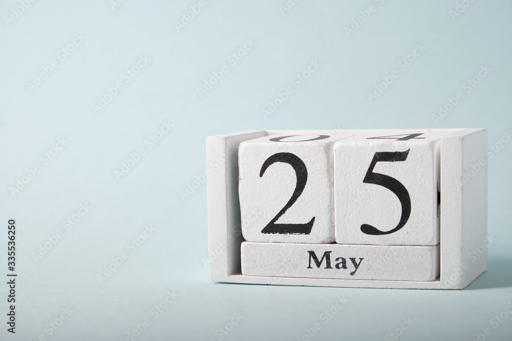 Wooden calendar on a blue background with the date of May 25 Wooden calendar on a blue background with the date of May 25