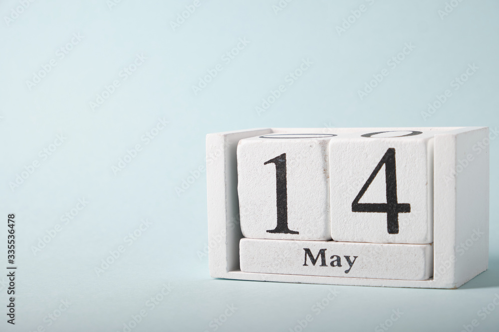 Wooden calendar on a blue background with the date of May 14 Wooden calendar on a blue background with the date of May 14