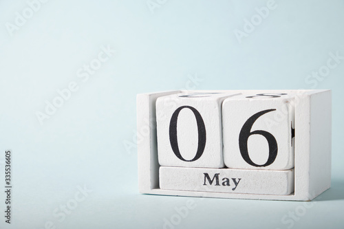 Wooden calendar on a blue background with the date of May 6 © grek881