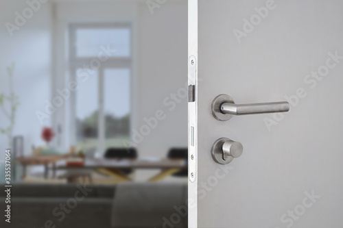 Digital Door handle or Electronics knob  for access to room security, Door wooden half opening through interior living room background, selective focus photo